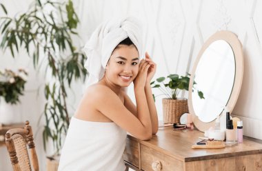 Aynanın önünde oturan Asyalı kadının yan görünüşü