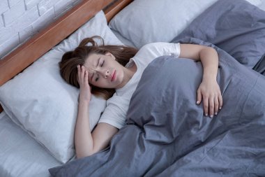 Psikolojik sağlık hizmeti. Üzgün kadın yatakta tek başına yatıyor, depresyon geçiriyor ya da uyku bozukluğu yaşıyor, üst tabaka.