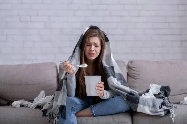 Concetto di alimentazione stressante. Signora sconvolta mangiare gelato e piangere sotto plaid caldo a casa — Foto Stock