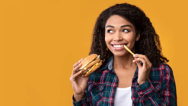 Engraçado Africano americano senhora comer hambúrguer e batatas fritas — Fotografia de Stock