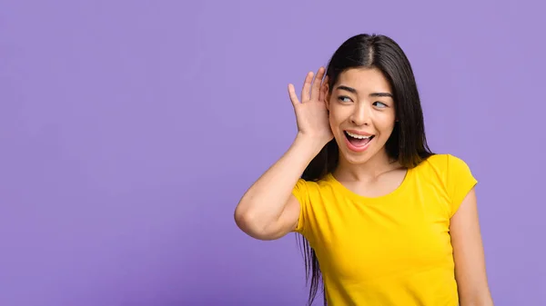 Gossip Concept. Curioso asiático mulher segurando mão perto da orelha, tentando ouvir informações — Fotografia de Stock