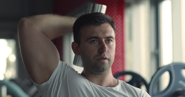 Närbild porträtt av bodybuilder tränar tricepsträning, träna med hantel på gym — Stockvideo