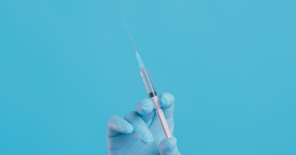Zbliżyć ujęcie trzymającej za rękę strzykawki ze szczepionką, powoli naciskając ją, wypuszczając pęcherzyki powietrza — Wideo stockowe