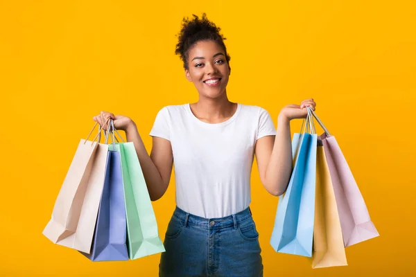 Retrato de mujer negra alegre sosteniendo bolsas de compras —  Fotos de Stock