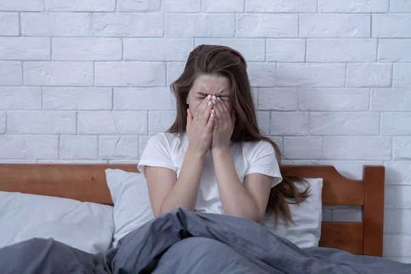 Wanita milenial tertekan duduk dan menangis dengan tangan di atas wajah di kamar tidur — Stok Foto