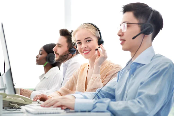 Conceito de telemarketing. Operadores de linhas directas felizes que vendem bens ou serviços através da telefonia VoIP no call center — Fotografia de Stock