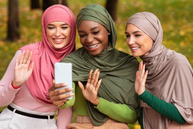 Akıllı Telefonlu Üç Modern Müslüman Kadın Dışarıda Video Çağrısı Yapıyor