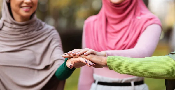 Vereinigte muslimische Frauen im Hijab, die im Freien händchenhaltend, beschnitten — Stockfoto