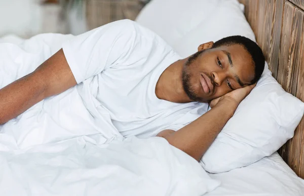 Deprimido negro chico acostado teniendo insomnio en el dormitorio en casa — Foto de Stock