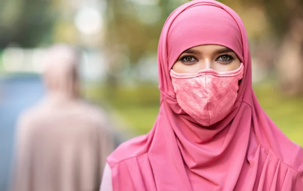 Mujer árabe en máscara protectora de la cara posando al aire libre — Foto de Stock