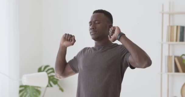 Schöner schwarzer Kerl wacht langsam auf und dehnt sich faul zu Hause — Stockvideo