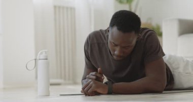 Genç Afro-Amerikan adam kalas egzersizi yapıyor, akıllı adamlarıyla antrenman modunu açıyor.