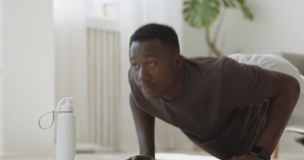 Junger afrikanisch-amerikanischer Mann übt Liegestütze, Übungen zu Hause — Stockvideo