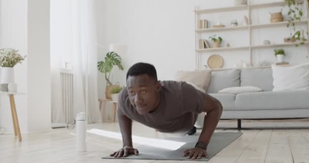 Young sporty black man doing push ups, exercising on floor — Stock Video