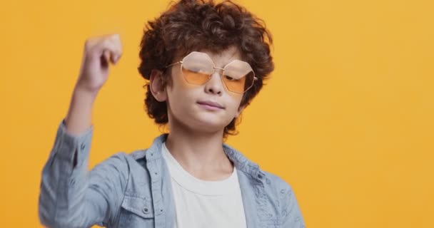 Awesome idea. Cool little boy in sunglasses gesturing thumb up — Stock Video