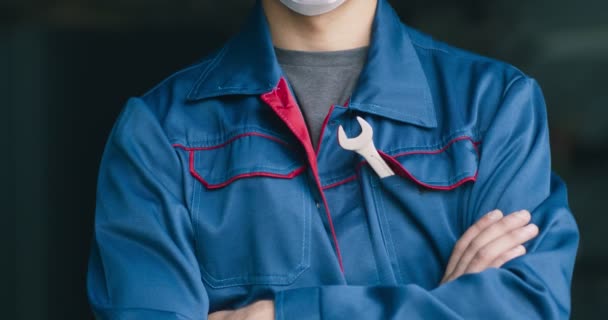 Mecánico de coche posando en máscara médica protectora, de pie en taller de reparación — Vídeos de Stock