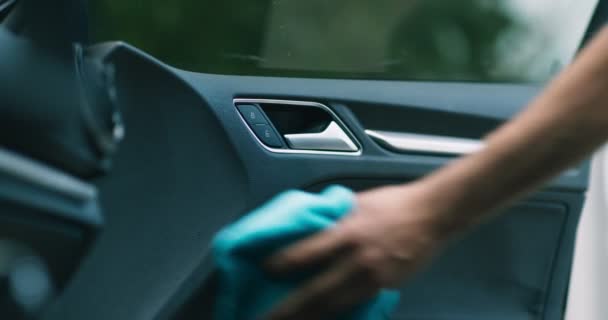 Professionele auto schoonmaak service. Werknemershanden spuiten en vegen deur in de auto salon — Stockvideo