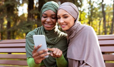 Modern Müslüman Kadın Dışarıda Arkadaş İçin Akıllı Cep Telefonu Uygulaması Öneriyor