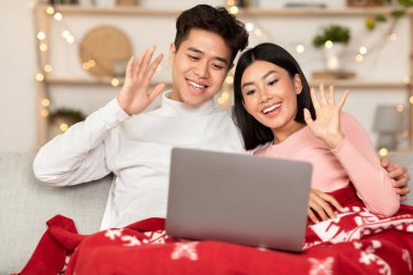 Bilgisayarlı çift evde Noel 'i kutlamak için video görüşmesi yapıyor.