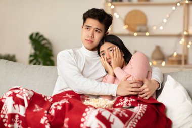 Japon aile çifti TV 'de korku filmi izliyor.