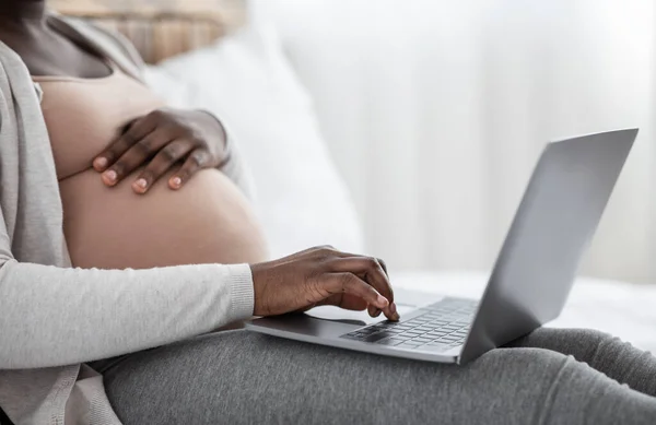 Zwangerschap en technologie. Onherkenbare zwarte zwangere dame met behulp van laptop thuis, Gehakt — Stockfoto