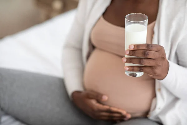 Embarazo y Calcio. negro embarazada madre bebiendo leche y abrazando vientre, recortado — Foto de Stock