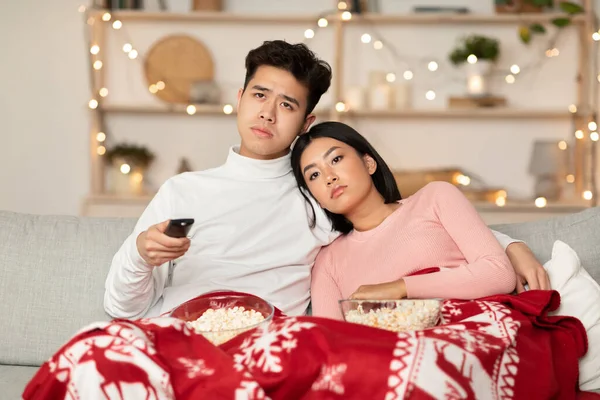 Verveeld aziatisch paar kijken tv vieren Kerstmis thuis — Stockfoto