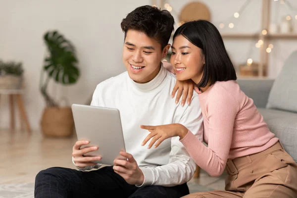 Japonský tisíciletý pár pomocí digitální tablety sedí spolu doma — Stock fotografie
