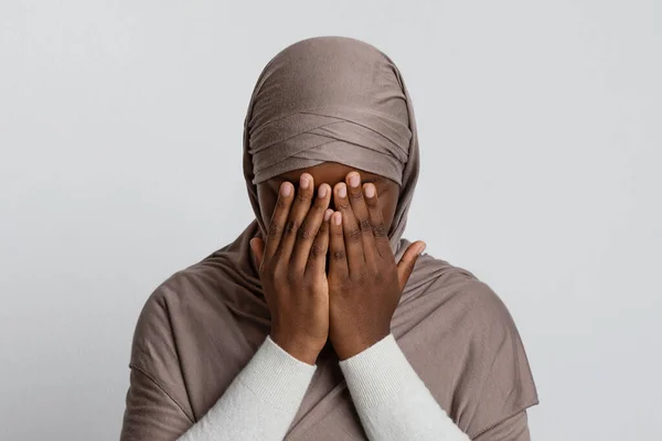 Muszlim diszkrimináció. Ijedt fekete iszlám nő hidzsábi takaró arc kezével — Stock Fotó