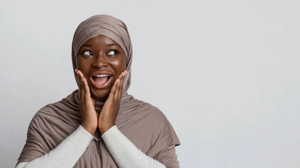 Σοκαρισμένη Αφρικανή μουσουλμάνα με χιτζάμπ κοιτάζει το χώρο αντιγραφής με ενθουσιασμό. — Φωτογραφία Αρχείου