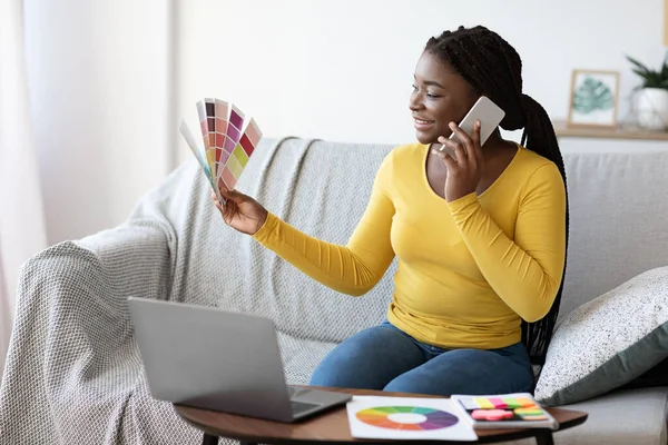 Jovem preto senhora segurando cor Swatch e falando no celular em casa — Fotografia de Stock