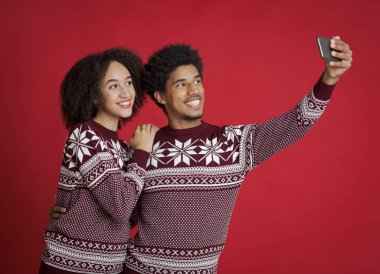Benzer yeni yıl kıyafetleri içindeki erkek ve bayan selfie için mutlu bir poz veriyor.