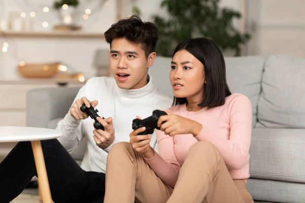 Chinês Millennial casal jogando jogo de computador sentado em casa — Fotografia de Stock