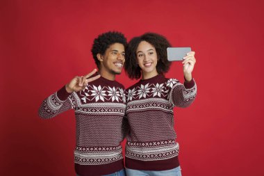 Kırmızı Noel elbiseli sevgililer selfie çekiyorlar.