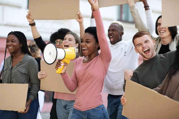 Felices manifestantes caminando por la calle con pancartas en blanco y megáfono — Foto de Stock