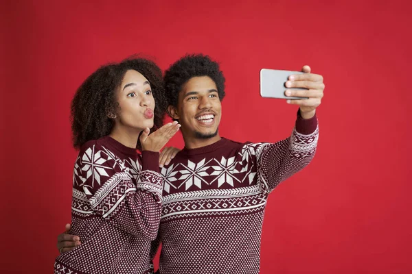 Selfie eines verliebten Paares. Glücklicher afrikanisch-amerikanischer Mann hält Smartphone, Dame pustet Kuss oder macht Videoanruf — Stockfoto