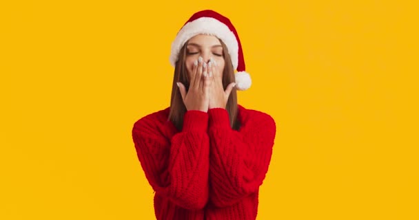 Adorável mulher milenar em camisola vermelha e chapéu de Papai Noel enviando beijo golpe para a câmera e sorrindo — Vídeo de Stock