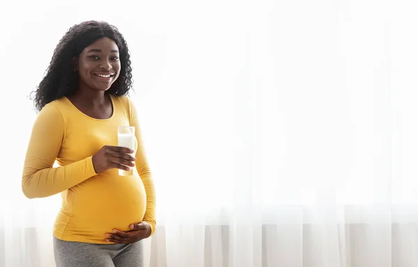 Mulher grávida afro-americana alegre segurando copo de leite — Fotografia de Stock