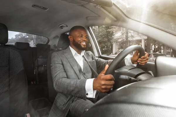 Positivo uomo d'affari afroamericano alla guida di auto, foto pannello frontale — Foto Stock