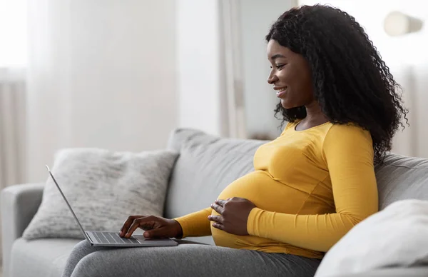 Wanita hamil hitam menggunakan laptop di rumah — Stok Foto