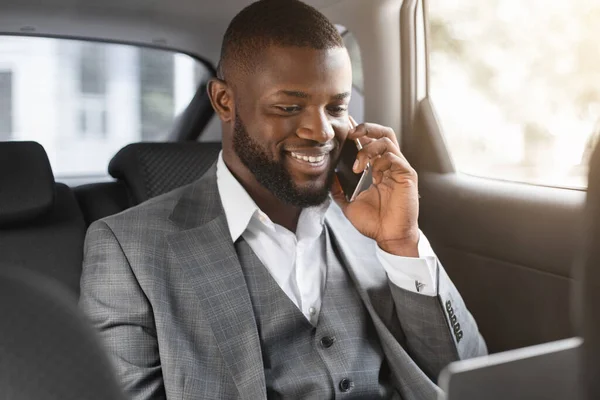 Sorridente uomo d'affari nero avendo conversazione su smartphone — Foto Stock