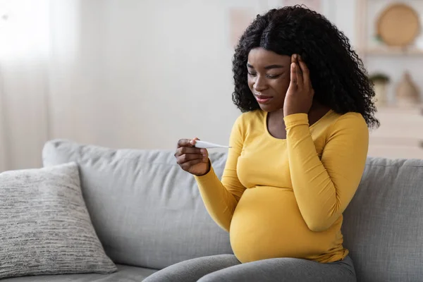 Donna nera incinta con mal di testa, misurazione della temperatura — Foto Stock