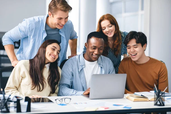 Grupp av internationella människor som använder bärbar dator och ler — Stockfoto