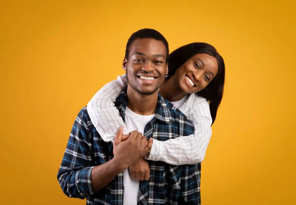 Sorrindo milenar casal afro-americano em abraços casuais e olhando para a câmera — Fotografia de Stock