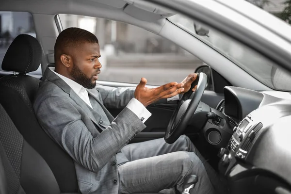 Indignato africano uomo conducente gesticolando e urlando durante la guida di auto — Foto Stock