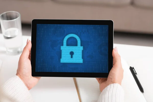 Woman using tablet, padlock icon on the screen