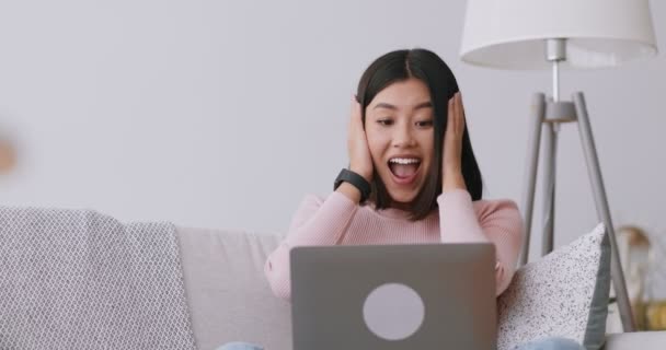 Happy asian lady enjoying success, reading e-mail on laptop at home, slow motion — Stock video