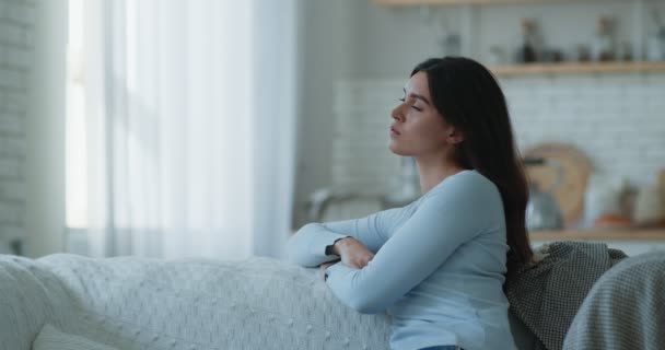 Depresión de otoño. Joven mujer triste sentada sola en casa, mirando a un lado, sufriendo de mal humor — Vídeo de stock