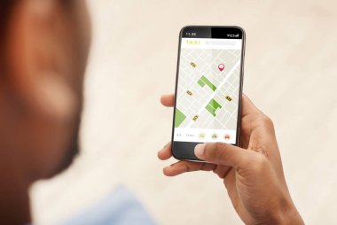 Siyah adam taksiye biniyor. Kapalı alanda uygulama kullanılıyor. Kesiliyor.