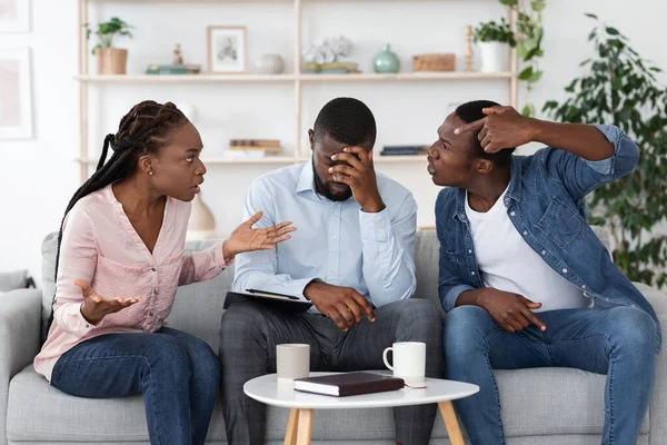 Tired Psychotherapist Sitting On Couch Between Quarreling Couple During Therapy Session — Stock Photo, Image